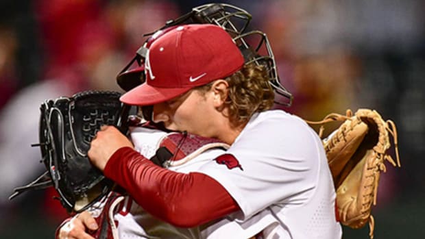 Arkansas pitcher Hagan Smith hugs catcher Parker Rowland after an emotion filled 7-5 win over Texas A&M Thursday night at Baum-Walker Stadium.